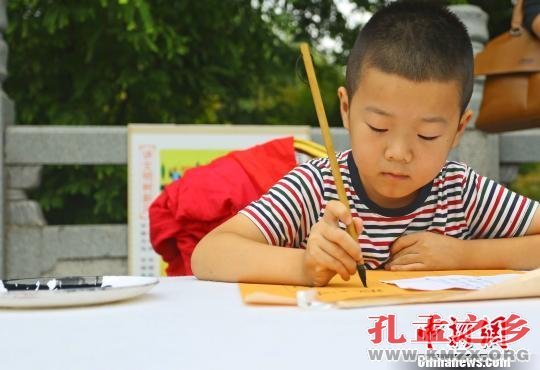 图为，王羲之故居洗砚池旁，青少年书法爱好者现场临帖。主办方提供