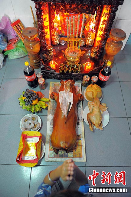 2011年2月2日，柬埔寨金边，当地华人华侨早上起床后在神像前祭拜，祈福平安。
