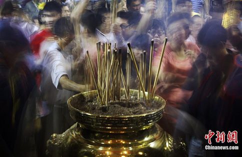 2月3日，新加坡当地的华人华侨起早来到寺庙内争烧头香，祈福来年健康平安。