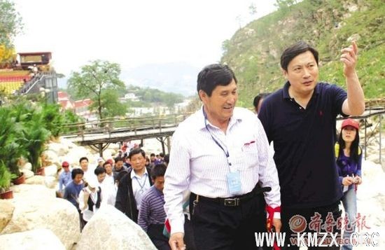 泰安市旅游局局长程明右为﹃登泰山保平安祈福团﹄做导游与?游客一同沿秦汉古道登泰山?本报记者　刘丽　摄
