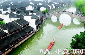 6月5日,龙舟驶过嘉兴月河历史街区,岸边的群众在观看比赛。行进中的龙舟和古色古香的月河历史街区构成了端午佳节一道古朴的风景线。
