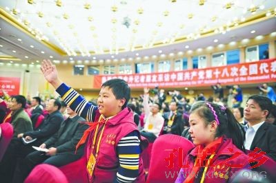 昨日，十八大新闻中心，中国少年报的小学生记者张佳鹤（左）和孙露源（右）一起跑新闻发布会，并积极举手提问。特派记者周超摄
