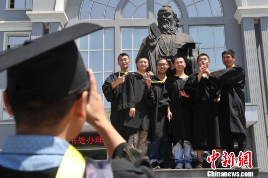 毕业生和孔子像亲密合影。　韦亮　摄