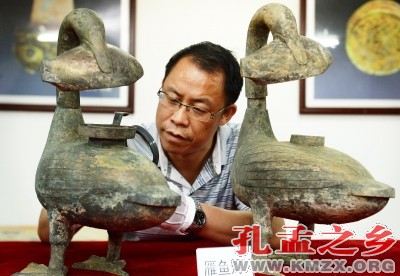 考古人员查看海昏侯墓出土的青铜雁鱼灯